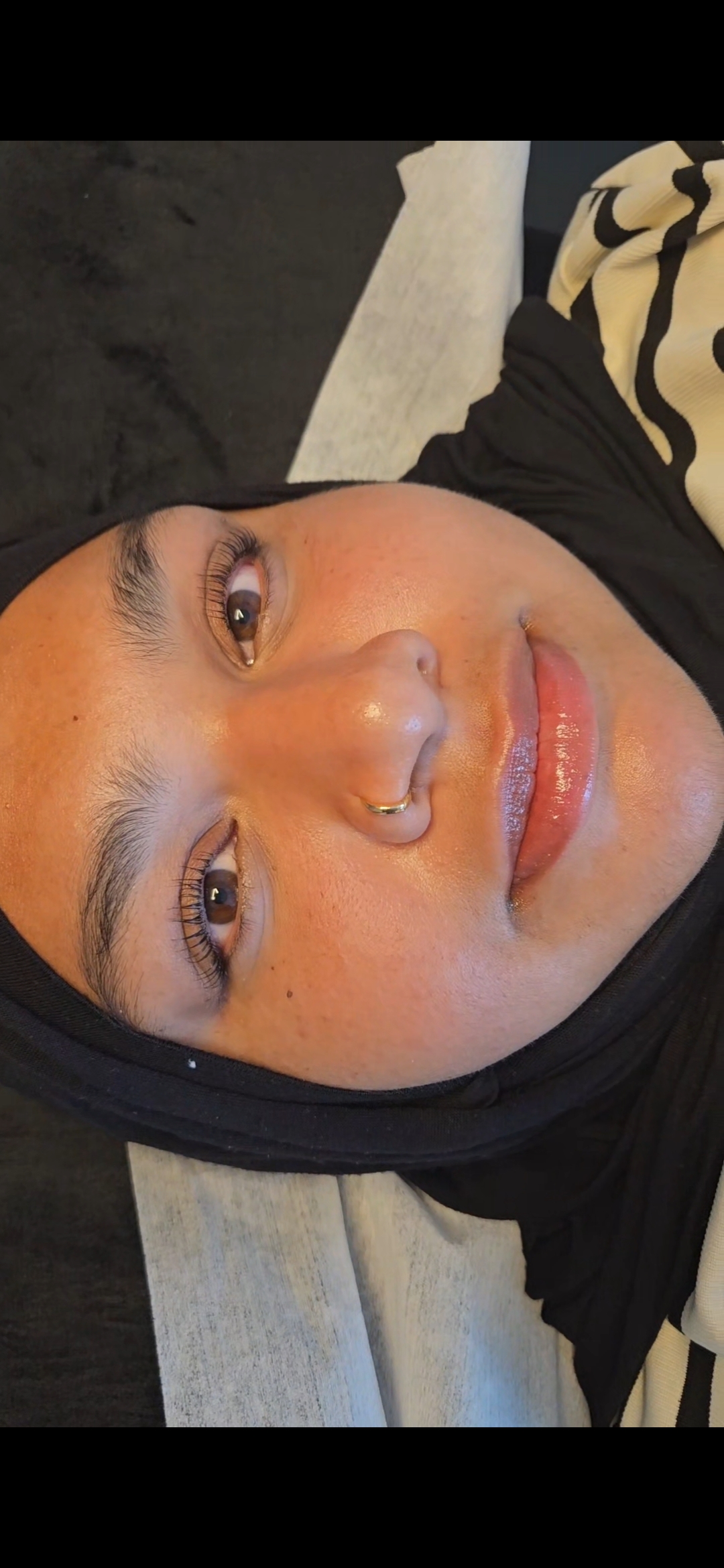 Client relaxing after a lash appointment with lifted, tinted lashes